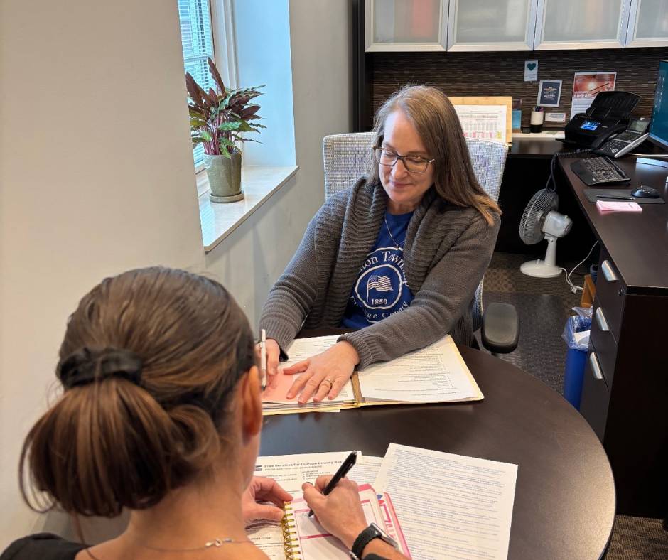 Milton Township caseworker with client in office at desk going over paperwork